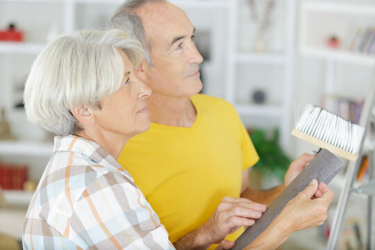 Happy Older Couple Painting A Wall