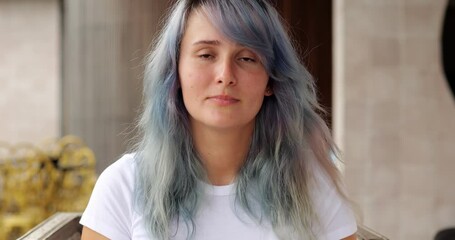 She can finally take mask off her face and breathe freely. Headshot of young woman with colored hair wearing black simple respirator mask. She look straight to camera, portrait shot