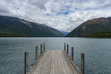 Dock on the edge of a large body of water with mountains in the background