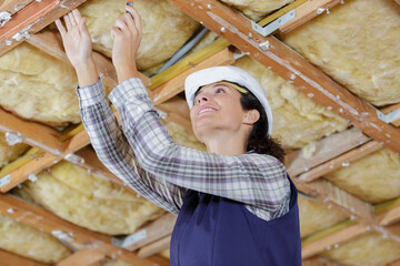 female builder working on wooden ceiling framework