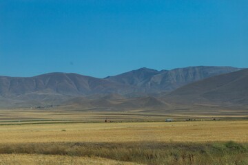 Obraz premium Rural landscape with mountains in the background and blue sky