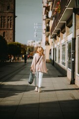 Vertical shot of a girl walking on the street on a sunny day