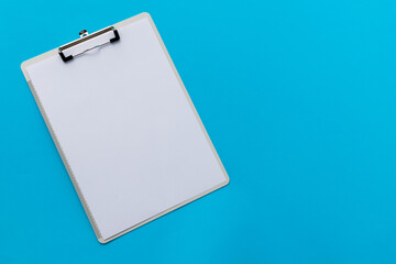 Clipboard with a paper on blue background
