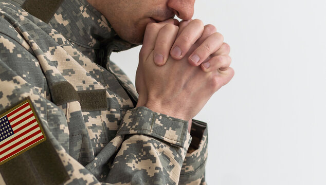 National American holidays. male praying soldier o with an American flag. Copy space. The concept of Veterans Day