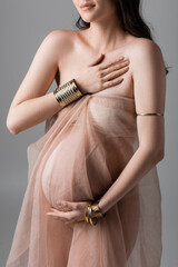 cropped view of stylish and elegant pregnant woman posing in golden accessories and transparent...