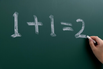 One plus one equals two on blackboard