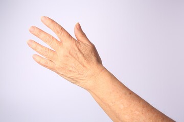 Closeup view of woman's hand with aging skin on white background