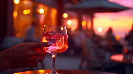  glass of champagne in hand on evening pink sunset summer beach restaurant ,candle blurred light on table in itali beach , romantic couple silhouette,generated ai
