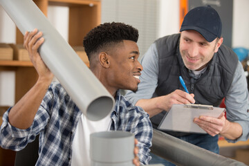 portrait of plumber with apprentice in domestic kitchen