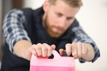 male worker carefully opening an industrial plastic container
