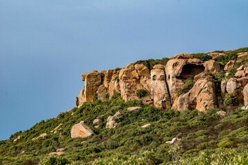 Fototapeta na wymiar Low angle shot of a rocky cliff over a seashore in Kef Abbed, Tunisia