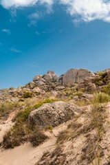 Vertical shot of a rocky cliff over a seashore in Kef Abbed, Tunisia