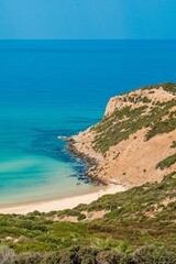 Vertical aerial view of a beautiful seashore with a rocky cliff in Kef Abbed, Tunisia