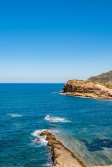 Vertical shot of a seascape with rocky cliffs on the coast of Korbous, Tunisia