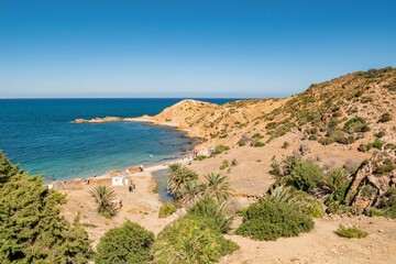 Fototapeta na wymiar Sandy mountains with green vegetation on the coast of Korbous, Tunisia