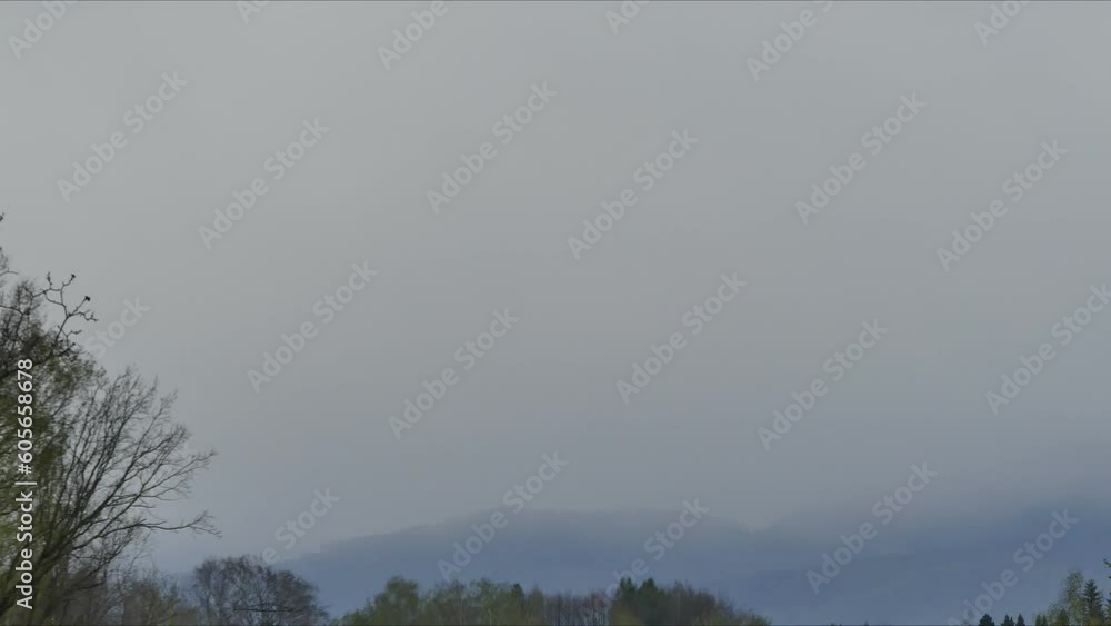 Poster changes in weather over mountains, greening trees and passing clouds and snowstorm - time lapse, clo