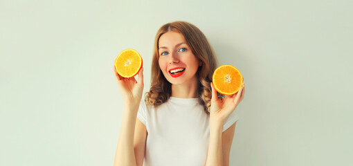 Summer, nutrition, diet and vegetarian concept. Happy healthy smiling young woman with slices of orange fruits on white background