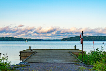 Wooden boat dock on the water with dramatic clouds in the background.