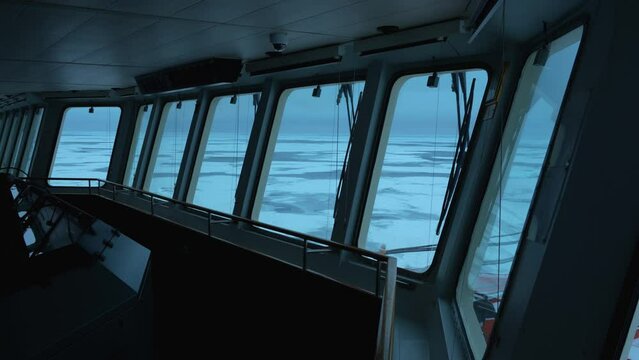 Ship. Navigation bridge. Frozen sea outside. Big windows in wheelhouse. Vessel in ice.