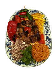 isolated turkish flavor meat shish kebab on a plate served with onion, tomato, pepper and bulgur...