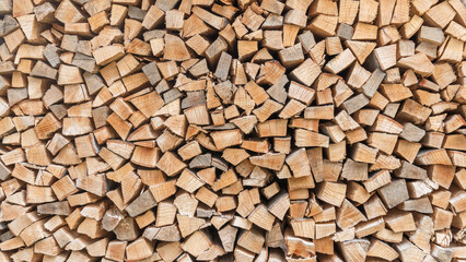 Firewood stack background of woodpile pattern cut from tree wood log with natural texture for fireplace fagot in winter