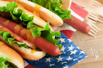 4th of July American Independence Day traditional picnic food. Hot dog with potato chips and cocktail, American flags and symbols of  USA Patriotic picnic holiday on wooden background. Top view.