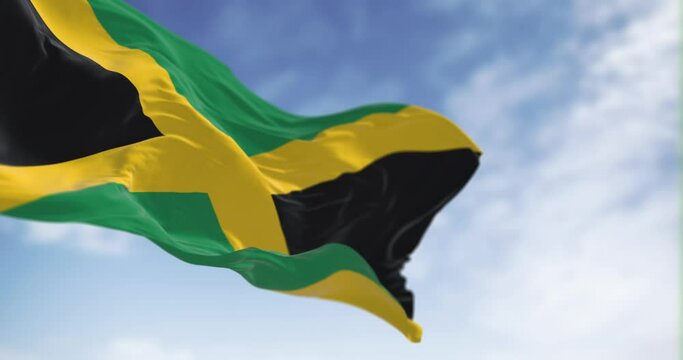 Seamless loop in slow motion of Jamaica national flag waving on a clear day