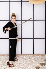 Attractive girl in kimono and Hair sticks against white background holds katana sword