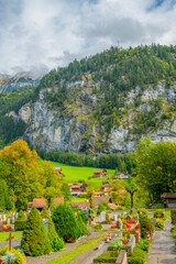 Amazing autumn landscape of touristic alpine village Lauterbrunnen with famous church and Staubbach waterfall. Location: Lauterbrunnen village, Berner Oberland, Switzerland, Europe.