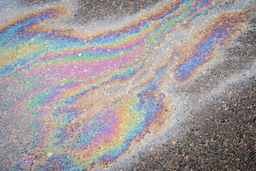 Rainbow gasoline oil spill on the pavement as a texture or background.