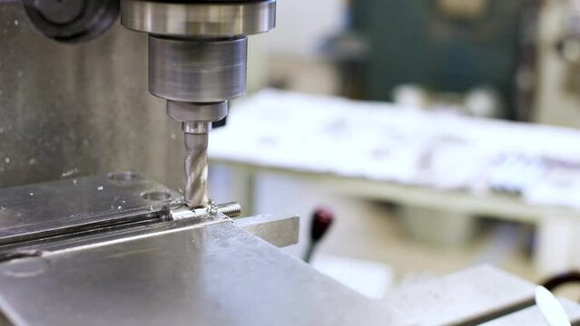 CNC milling machine for cutting stainless steel metal workpiece. Close-up of a cutter in action
