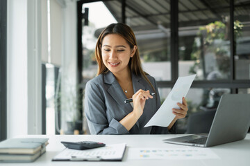 Asian businesswoman sit at their desks and calculate financial graphs showing results about their investments, planning successful business growth process