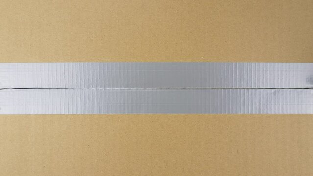 Unpacking cardboard. Chromakey transition. Opening parcel box with utility knife. View from above