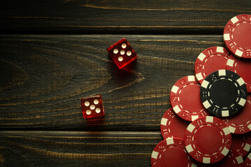 Poker dice on a black vintage table and chips from winnings. Free space for advertising. Gambling...