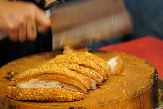 deep fried pork belly on a chopping board,Oriental roasted pork on a wooden chopping board,Oil-free frying concept
