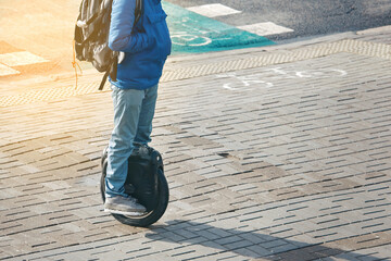 Man on mono wheel riding on city street. Man in protective gear moving on electric unicycle (EUC). Drive around city streets on monowheel. Boy riding on self balancing transporter with single wheel © Tricky Shark