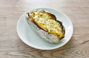 baking Japanese yam stuffing sweet corn seed with cheese in foil on plate