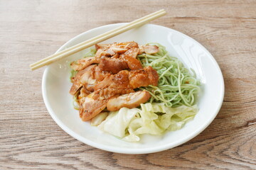 jade Chinese egg noodles topping Korean fried slice chicken with cabbage dressing sauce on plate