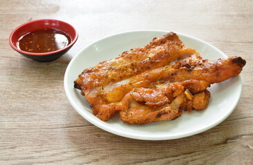 roasted chicken tight stabbing wooden stick on plate dipping with spicy sauce 