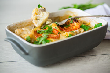 cauliflower baked with chicken fillet and mushrooms under cheese in a ceramic form