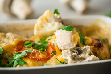 cauliflower baked with chicken fillet and mushrooms under cheese in a ceramic form