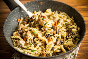 vermicelli cooked with mushrooms, meat and vegetables in a frying pan