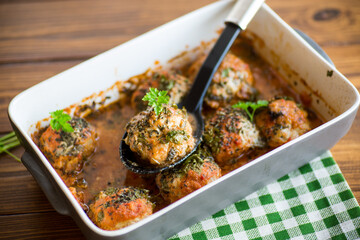 cooked meatballs from minced meat in a sauce in a ceramic form