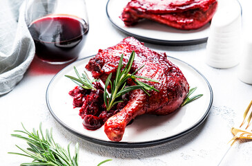 Baked duck legs in cherry and wine sauce with fresh rosemary. Gourmet dinner. White table background, top view