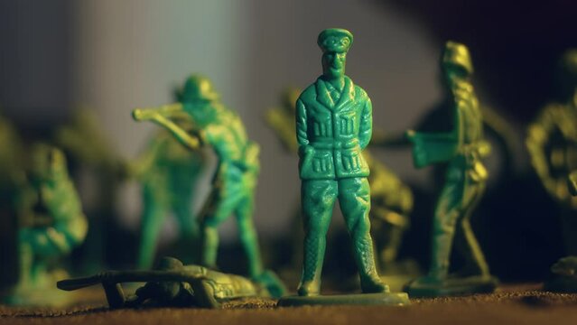 Regiment of toy soldiers with army general is defeated by hand of man. Demonstration of defeat on battlefield. Violence war resistance and peace without armored invasion