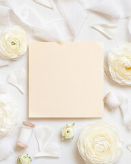 Obraz na płótnie Canvas Square Blank card near cream roses and white silk ribbons top view, wedding mockup