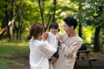 新緑の公園で微笑む家族のポートレート