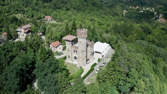 Marquee tent erected next to Castello Becchi surrounded by lush woods, aerial