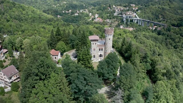Distinctive Castello Becchi in mountainous woody terrain. Aerial pullback