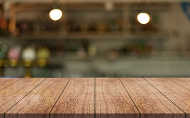 Empty wooden table top with lights bokeh on blur restaurant background.